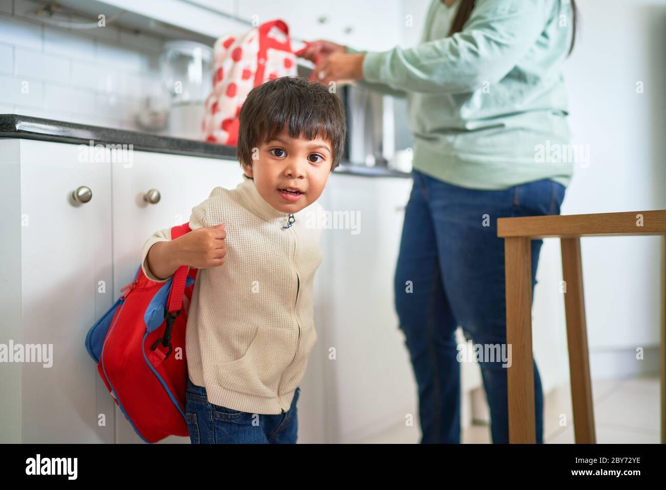 Portrait niedlichen Jungen mit Rucksack in der Küche Stockfoto