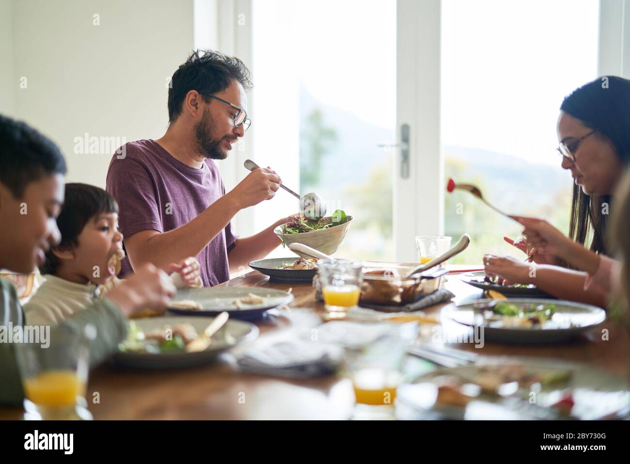 Familie beim Mittagessen am Esstisch Stockfoto