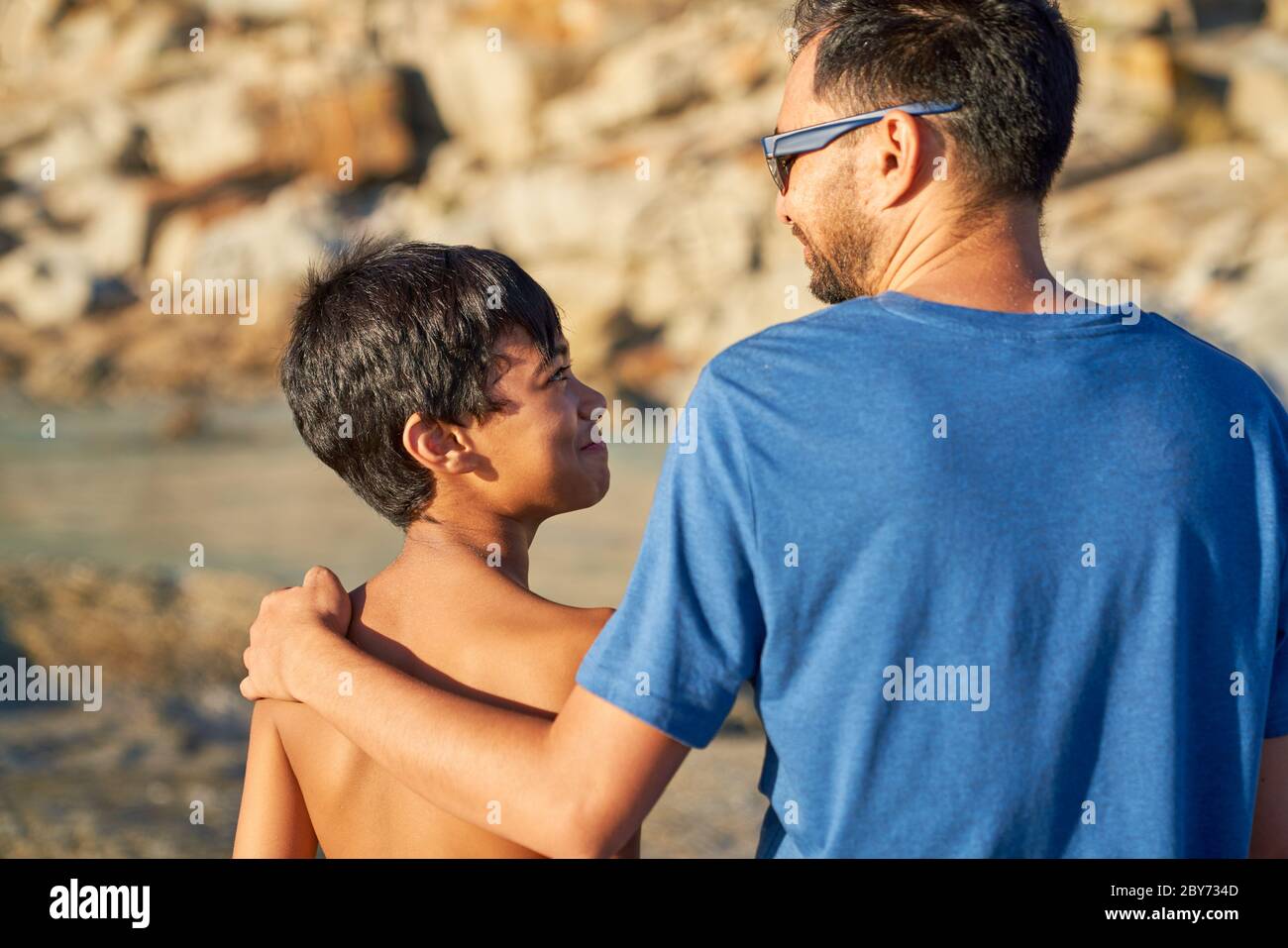 Liebevoller Vater und Sohn am sonnigen Strand Stockfoto