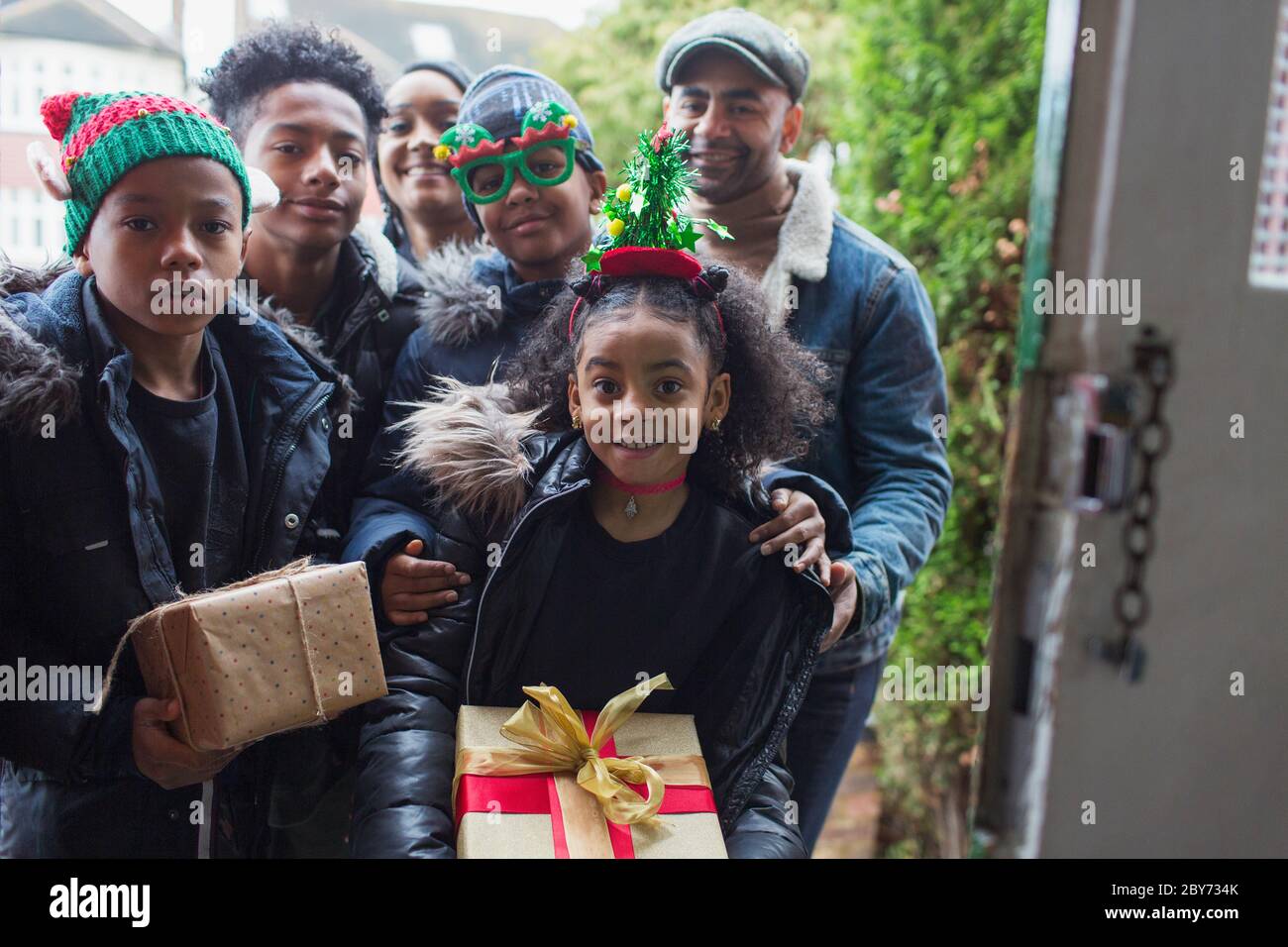 Portrait glückliche Familie liefern Weihnachtsgeschenke an der Haustür Stockfoto