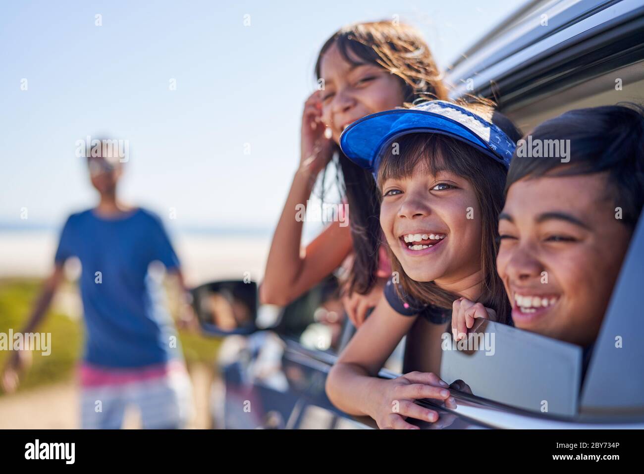 Portrait glückliche Kinder lehnen sich aus sonnigen Autofenster Stockfoto