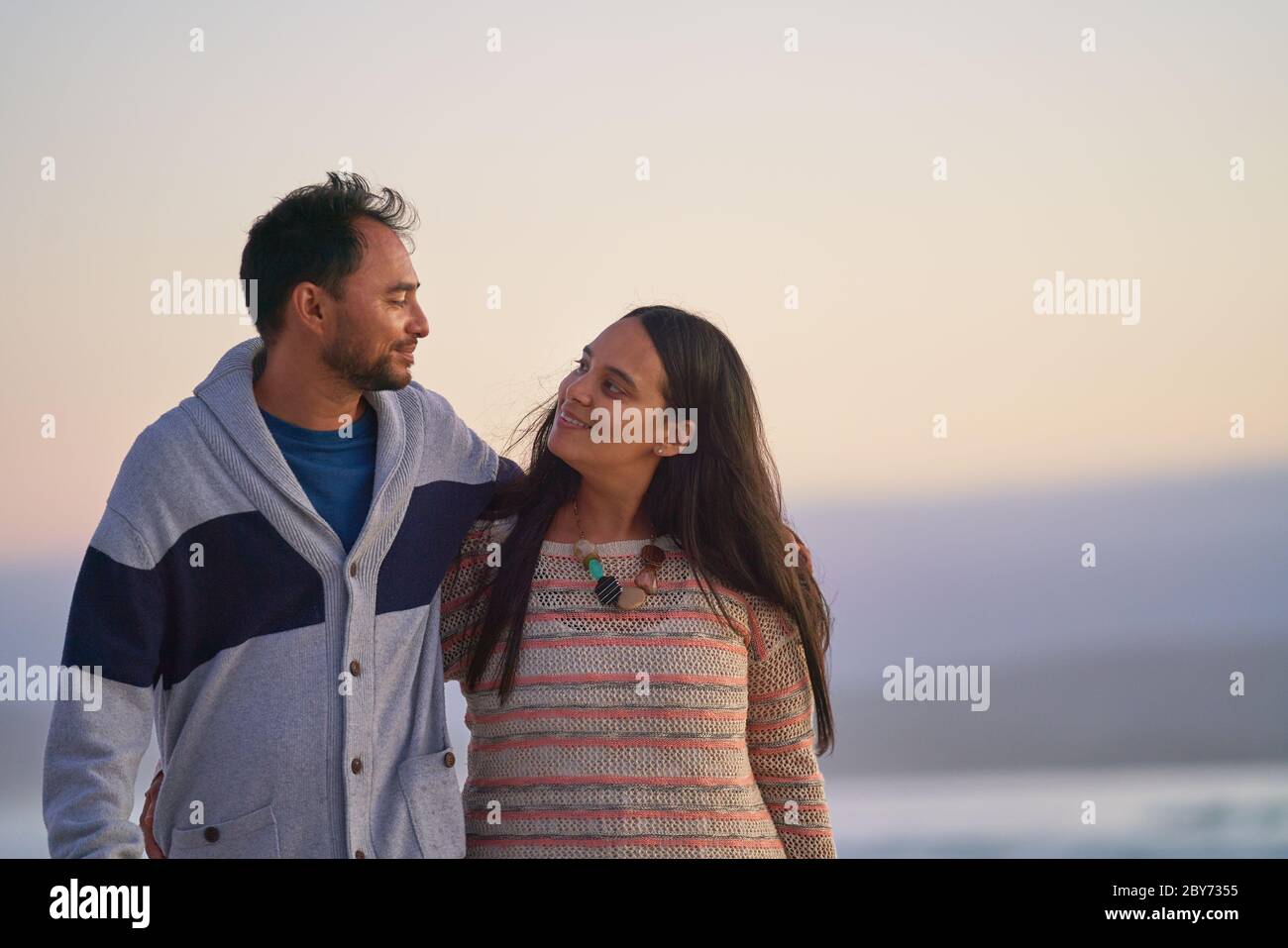 Glückliches liebevolles Paar umarmt am Strand Stockfoto