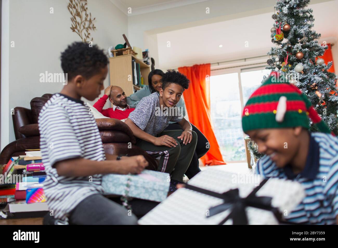 Familie Weihnachtsgeschenke im Wohnzimmer öffnen Stockfoto