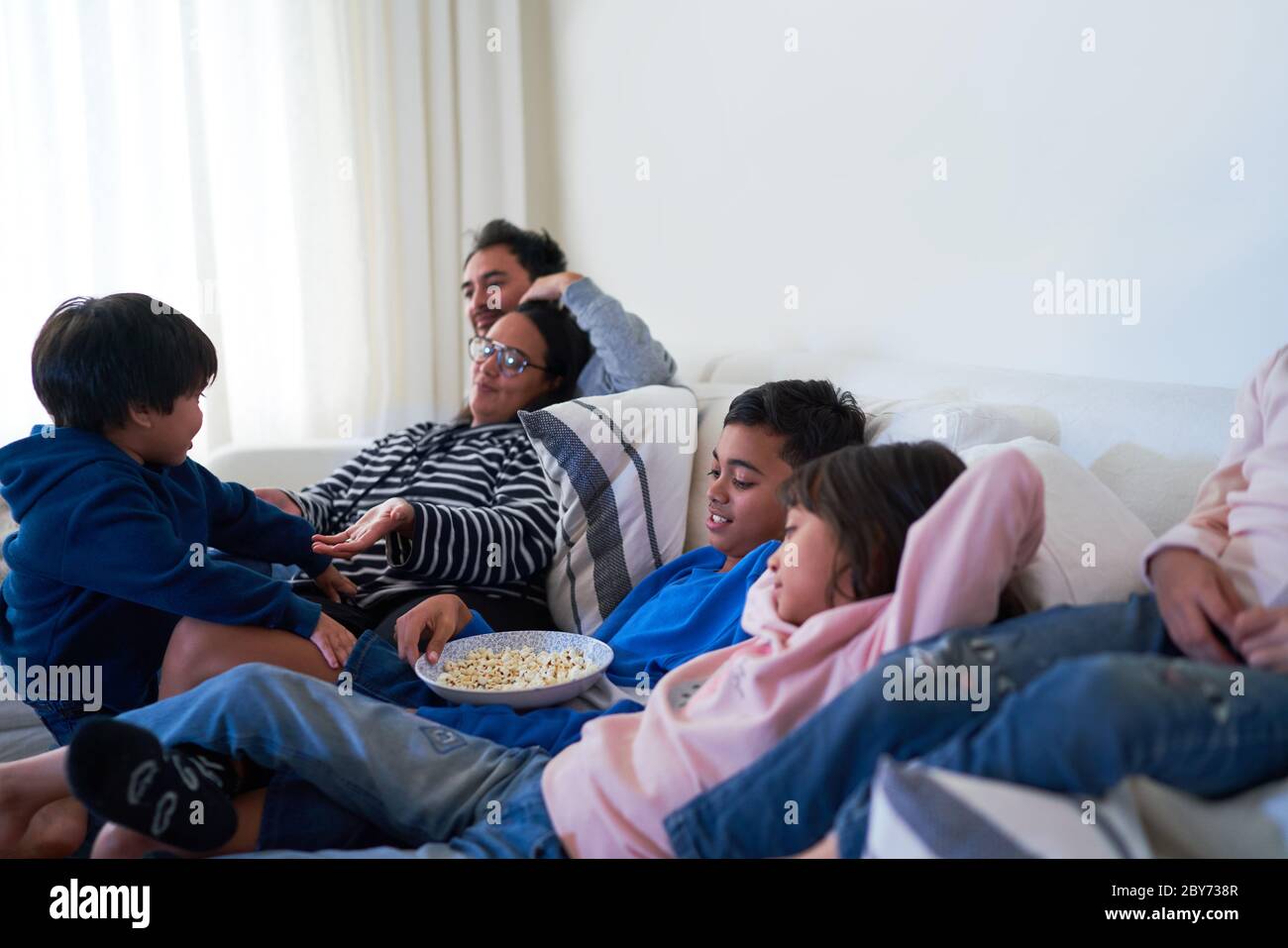 Familie entspannen und essen Popcorn auf Wohnzimmer Sofa Stockfoto