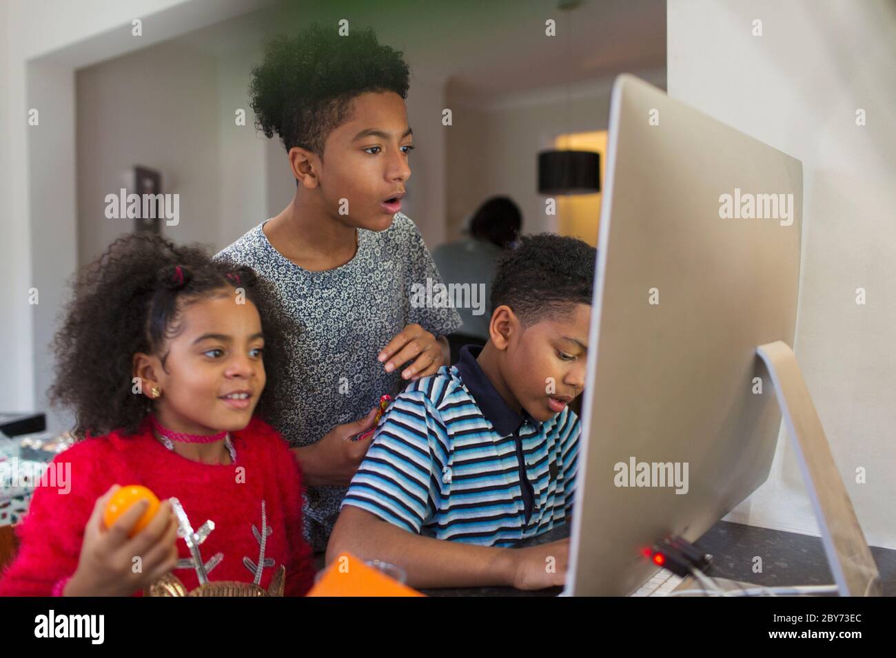 Brüder und Schwester, die Computer benutzen Stockfoto