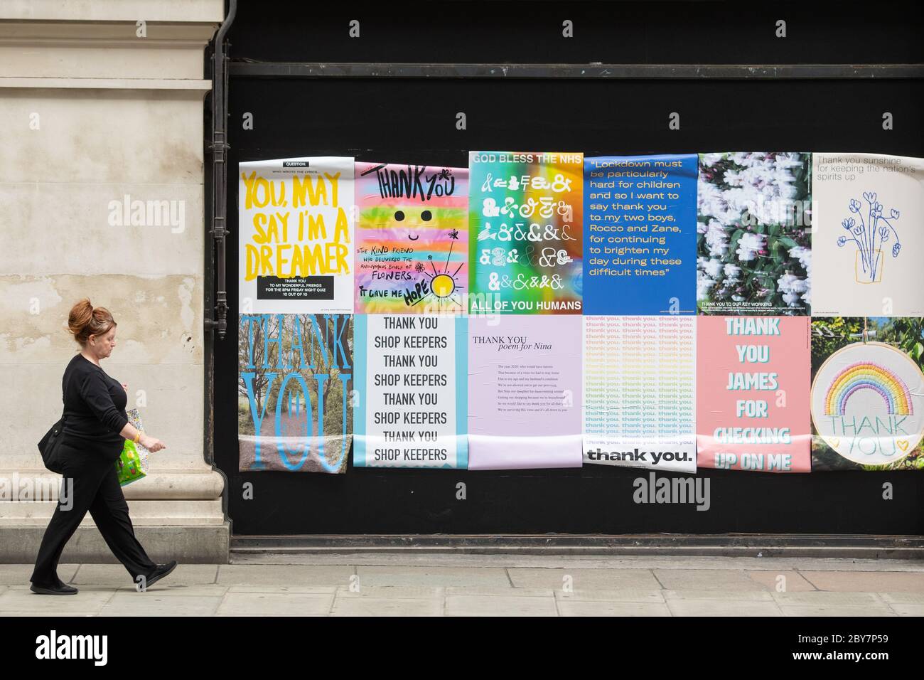 Eine Frau geht an den Fensterballen im Selfridge's in der Oxford Street, London vorbei und zeigt Dankesbotschaften von Selfridge's Mitarbeitern an Menschen, die ihnen während der Sperrung des Coronavirus geholfen haben. Stockfoto