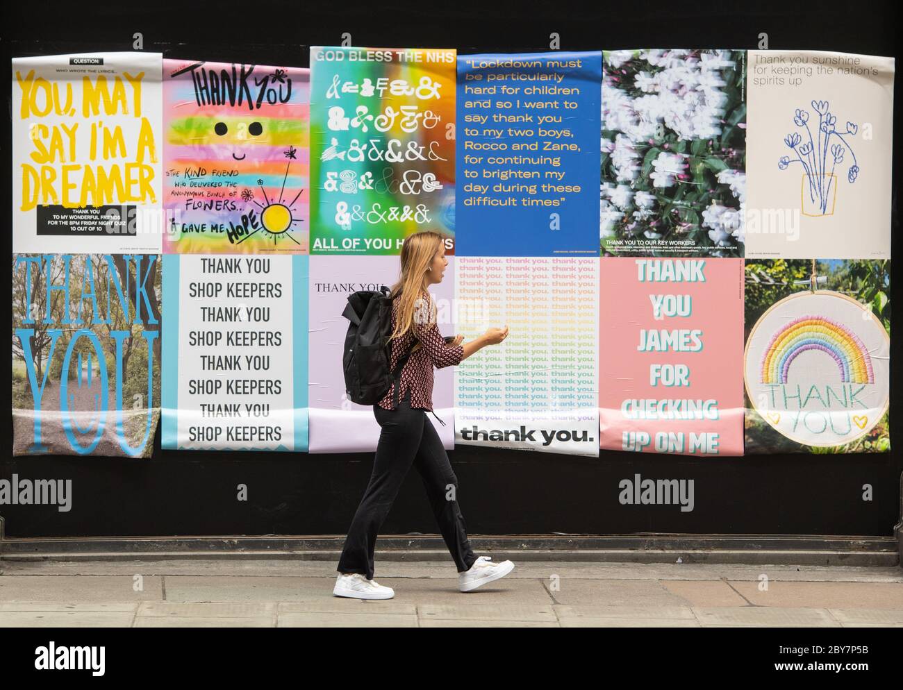 Eine Frau geht an den Fensterballen im Selfridge's in der Oxford Street, London vorbei und zeigt Dankesbotschaften von Selfridge's Mitarbeitern an Menschen, die ihnen während der Sperrung des Coronavirus geholfen haben. Stockfoto