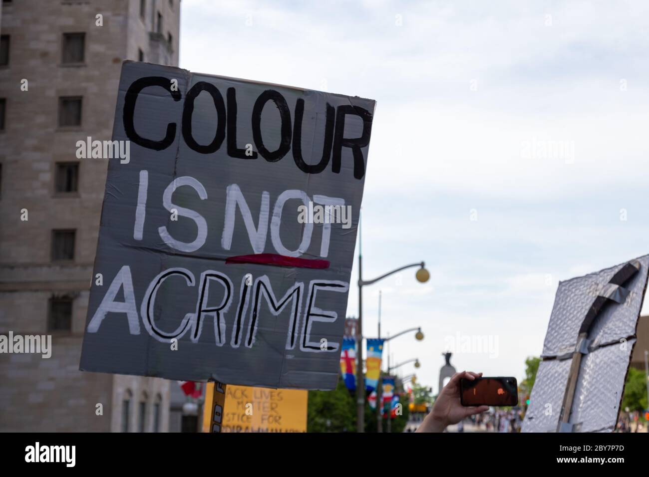 Bei einem Anti-Rassismus-Protest in der kanadischen Hauptstadt Ottawa hält ein Protestler ein Schild mit der Aufschrift "Farbe ist kein Verbrechen". Stockfoto
