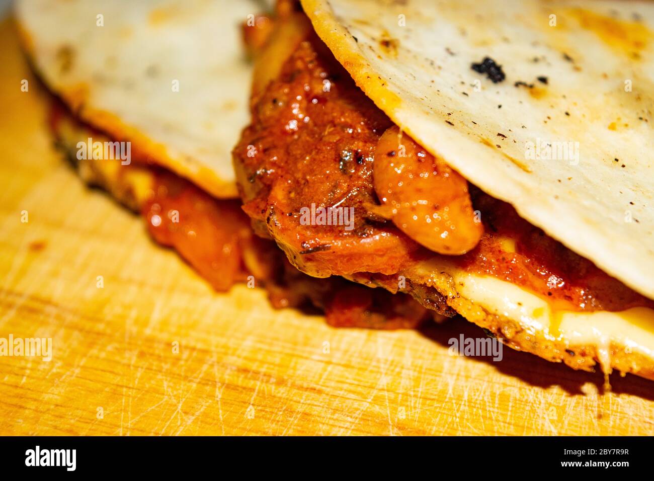 Quesadilla mit Hackfleisch, Wurst, roten Bohnen, Mais, Zwiebeln und Tomatensauce. Ein traditionelles mexikanisches Essen. Nahaufnahme Stockfoto