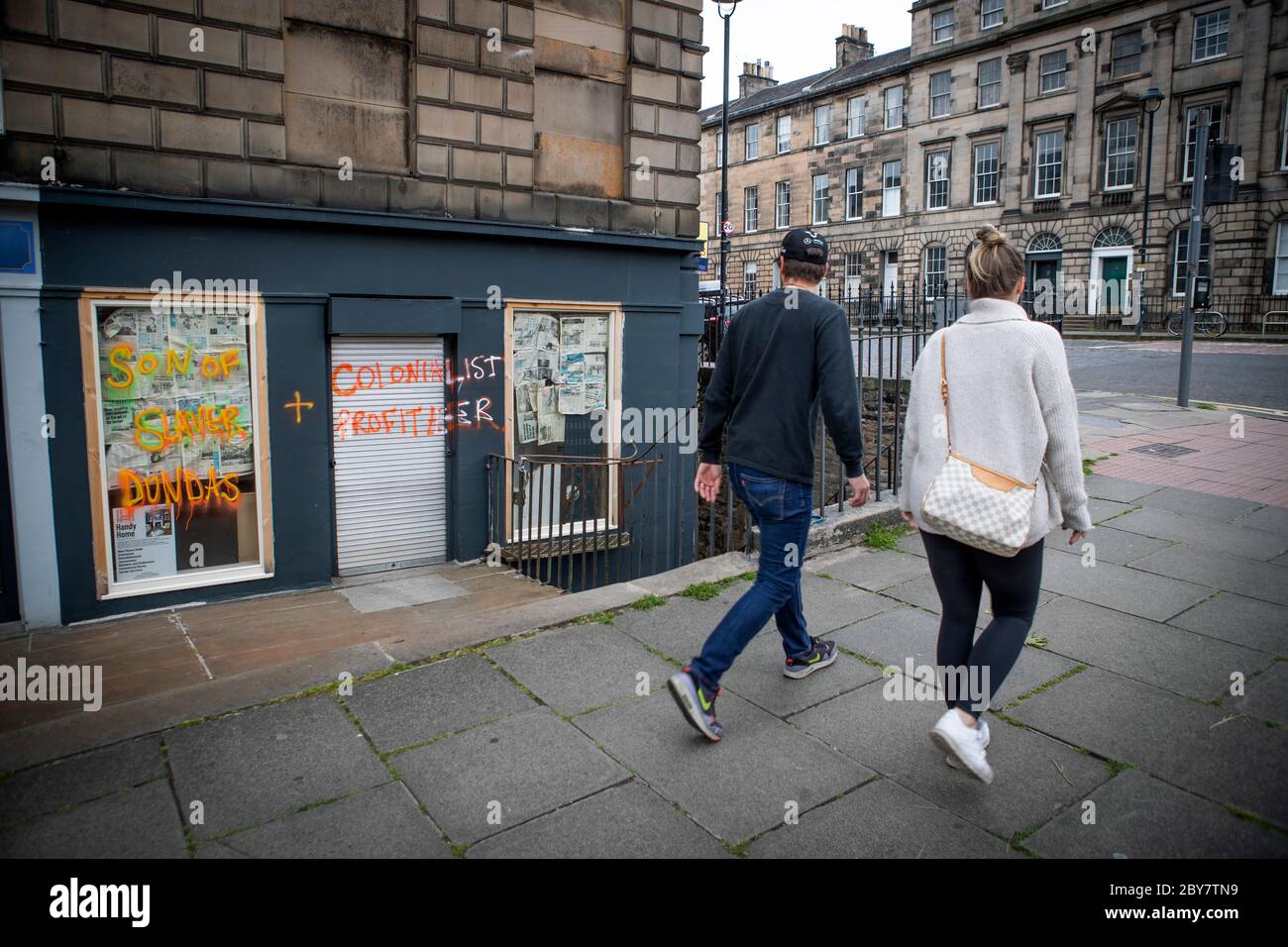 Graffiti mit der Aufschrift "Sohn des Sklaveniers Dundas und kolonialistischer Profiteer" erschien in einer vernagelten Ladenfront in der Dundas Street in Edinburgh. Stockfoto