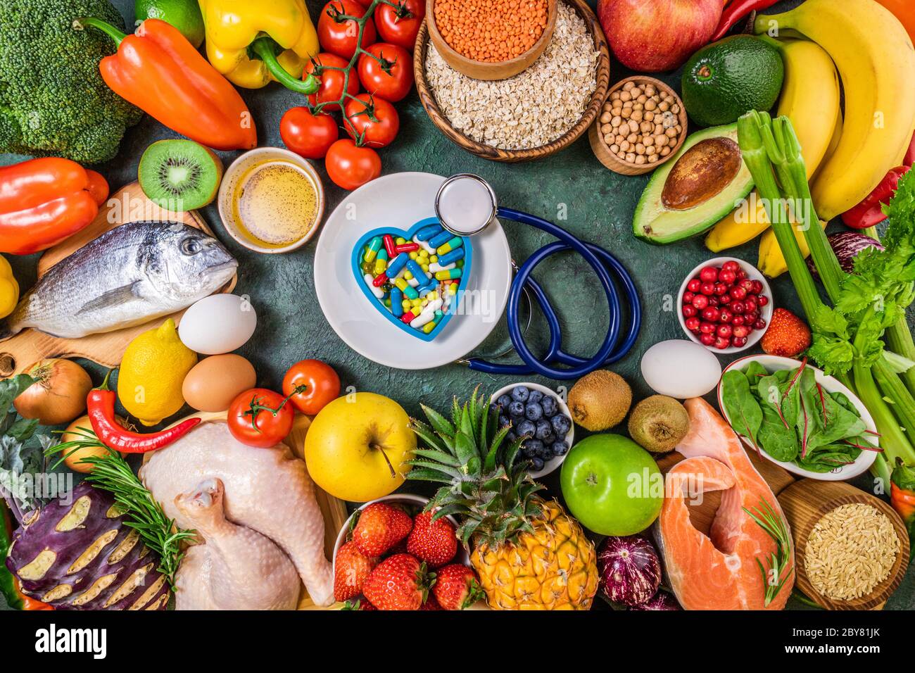 Hintergrund der gesunden Ernährung. Frisches Obst, Gemüse, Fleisch und Fisch auf dem Tisch. Lebensmittel zur Stärkung der Immunität. Wahl gesunde Ernährung oder Medizin Pillen Konzept. T Stockfoto