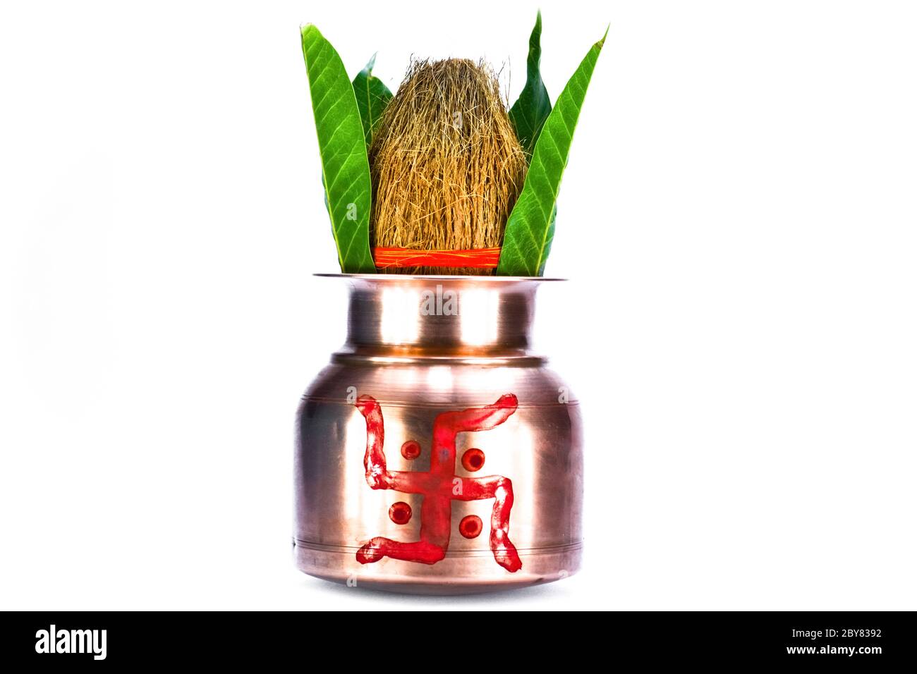 kalasch aus Kupfer mit Kokosnuss und Mangoblatt auf weißem Hintergrund isoliert Stockfoto