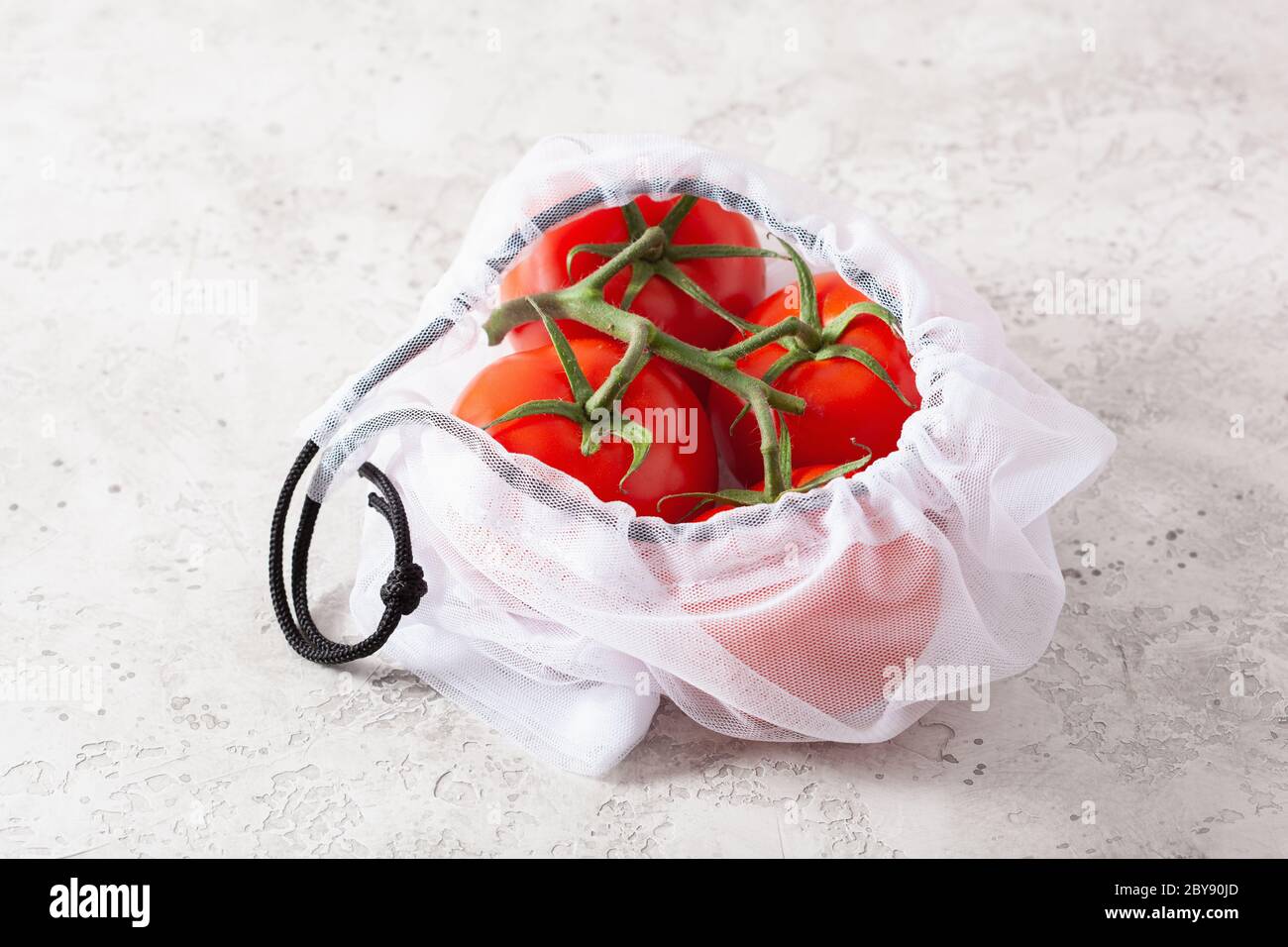 Tomaten Gemüse in wiederverwendbare mesh Nylon Tasche, Kunststoff sich null Abfall Konzept Stockfoto