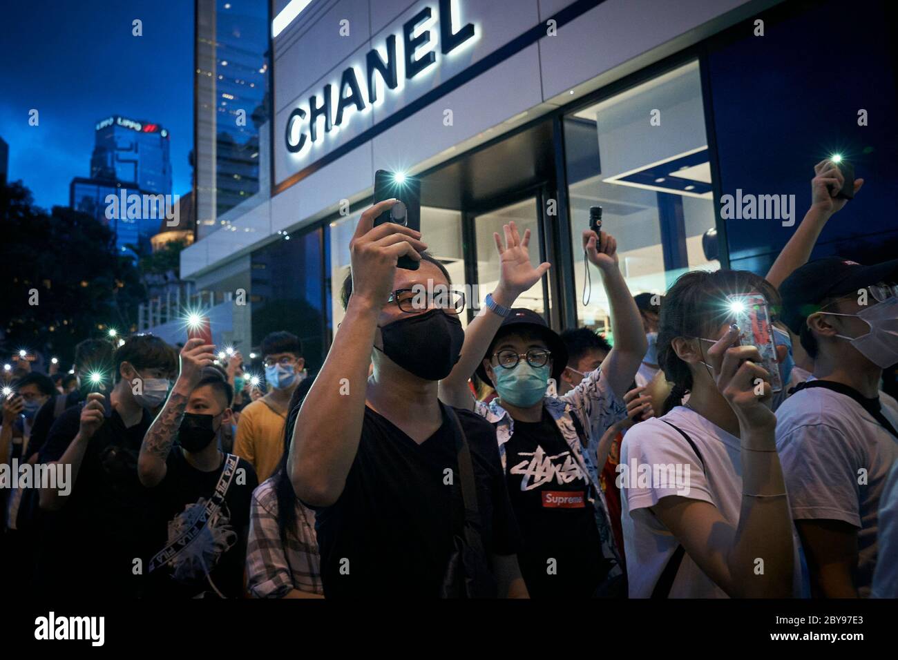 Junge Demonstranten halten das Licht ihrer Handys hoch und singen die Protestparolen „Kampf für Freiheit! Steht mit Hongkong!“ Hunderte Demonstranten gehen auf die Straßen der Innenstadt von Hongkong, um den ersten Jahrestag eines historischen marsches gegen die Auslieferungsrechnung zu begehen. Stockfoto
