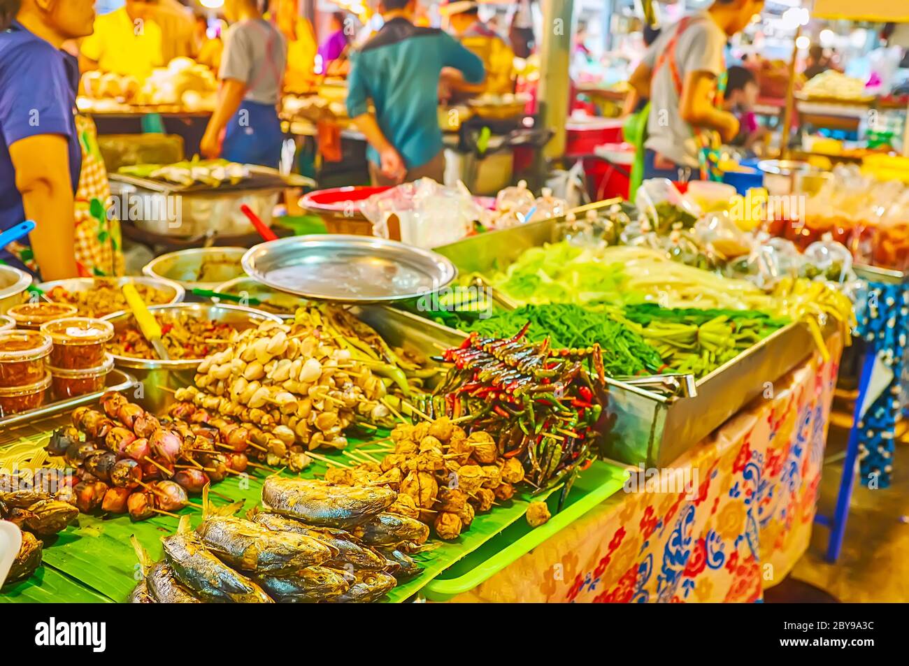Die Theke des Stall mit Haufen von leckeren thailändischen Grillgerichte auf Spieße - Makrele, Chili-Paprika, Knoblauch und Pilze, Talad Saphan Phut Markt, Bang Stockfoto