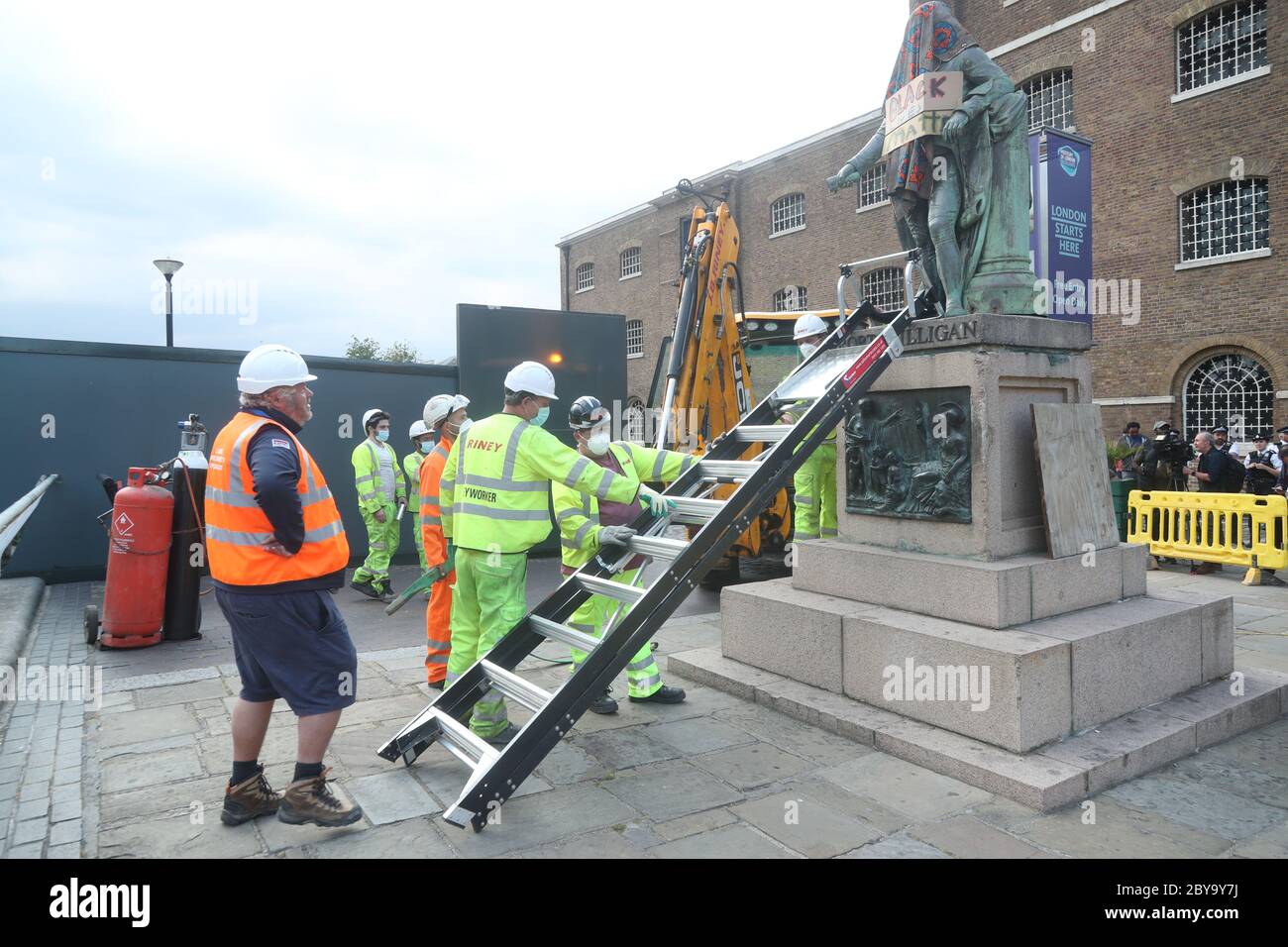 Arbeiter bereiten sich darauf vor, eine Statue des Sklavenbesitzers Robert Milligan am West India Quay, East London, abzubauen, während die Labour Councils in ganz England und Wales beginnen, Denkmäler und Statuen in ihren Städten zu überprüfen. Nach einem Protest wurden in Bristol die Statue eines Sklavenhändlers von Anti-Rassismus-Aktivisten niedergerissen. Stockfoto