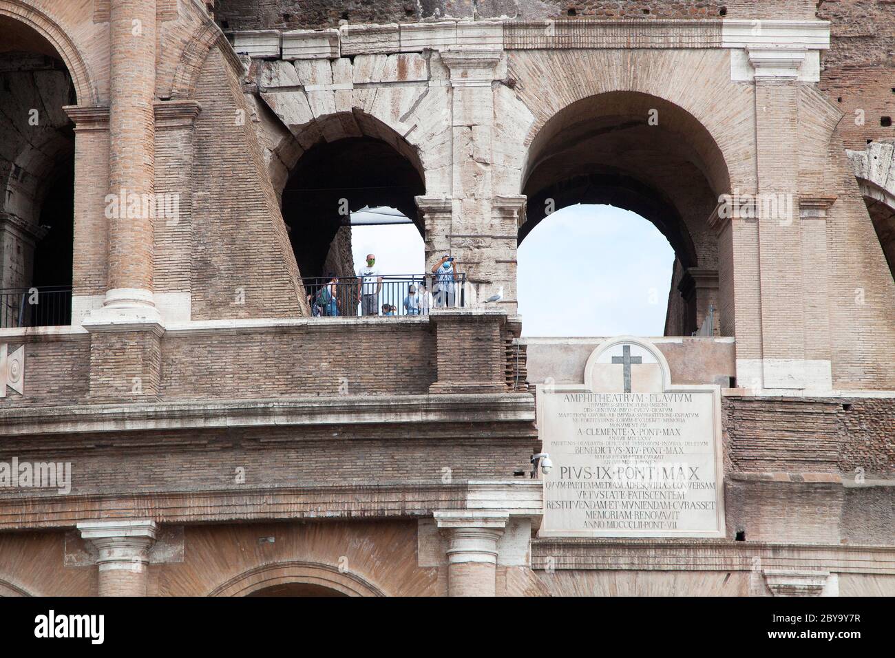 Italien Wiedereröffnung, Start Phase 3. Personen, die eine Schutzmaske tragen, gehen am Dienstag, den 02. Juni 2020 in Rom in der Straße Fori Imperiali nahe dem Kolosseum (Colosseo) umher. Stockfoto