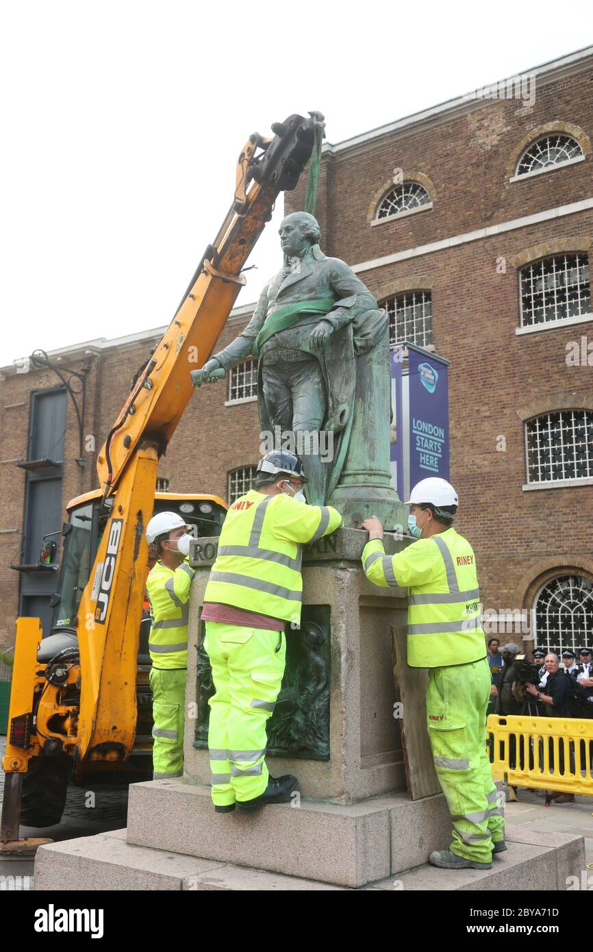 Arbeiter bereiten sich darauf vor, eine Statue des Sklavenbesitzers Robert Milligan am West India Quay, East London, abzubauen, während die Labour Councils in ganz England und Wales beginnen, Denkmäler und Statuen in ihren Städten zu überprüfen. Nach einem Protest wurden in Bristol die Statue eines Sklavenhändlers von Anti-Rassismus-Aktivisten niedergerissen. Stockfoto