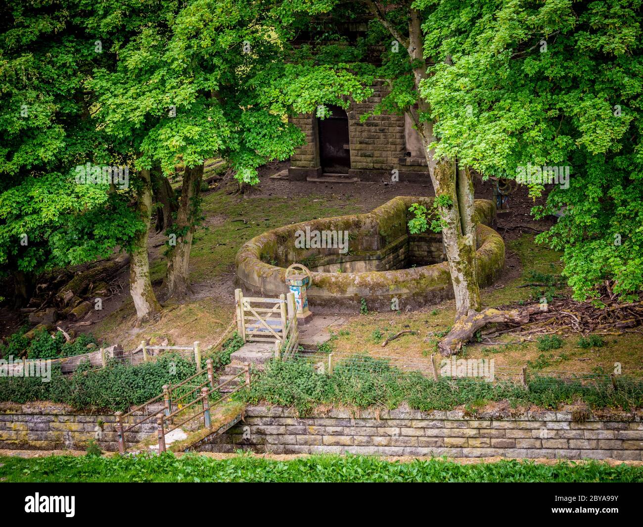 Steingebäude am Rande des unteren Reservoirs von Castleshaw mit oberem Überlauf des Reservoirs im Vordergrund. Oldham. Stockfoto