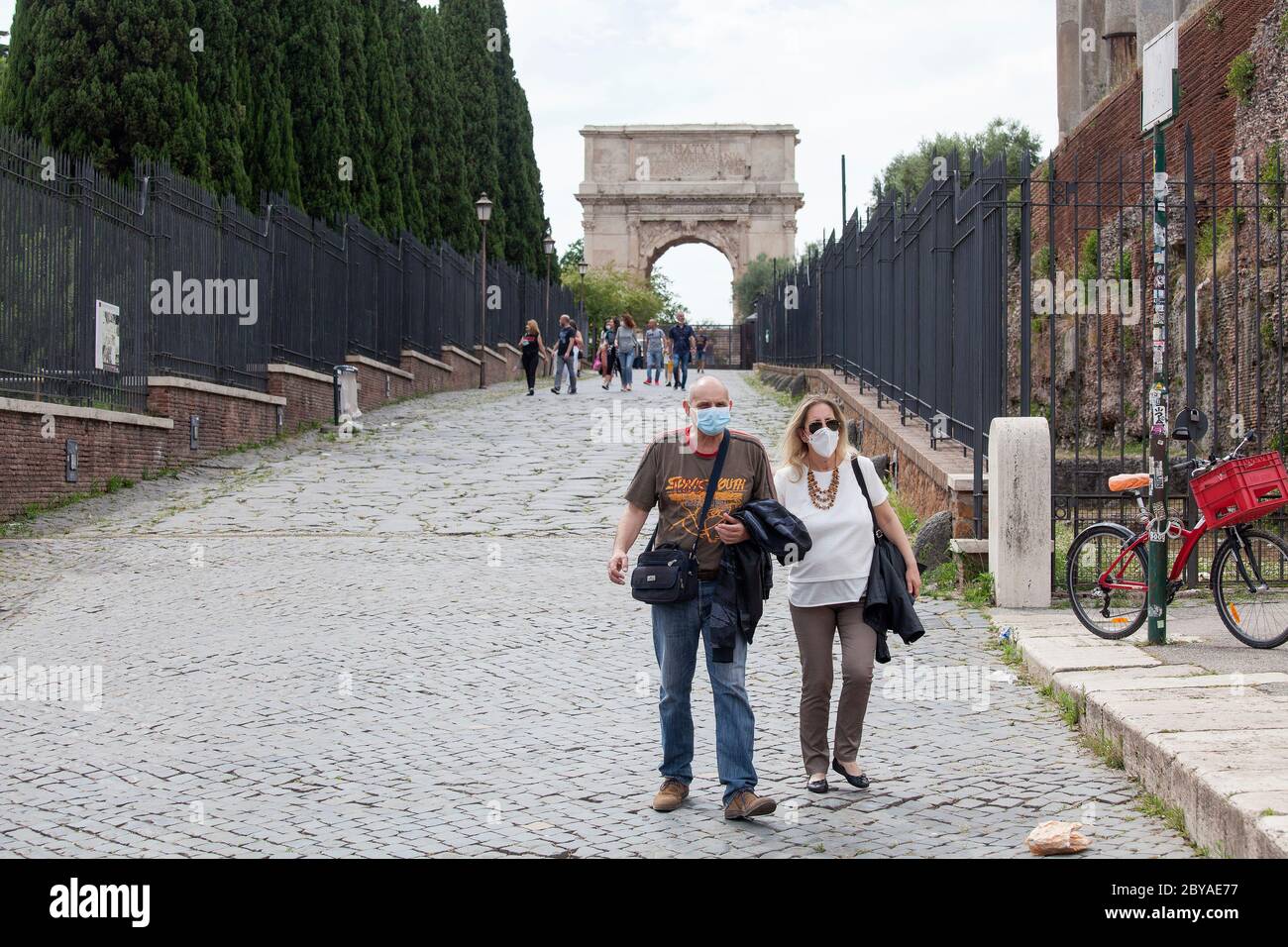 Italien Wiedereröffnung, Start Phase 3. Personen, die eine Schutzmaske tragen, gehen am Dienstag, den 02. Juni 2020 in Rom in der Straße Fori Imperiali nahe dem Kolosseum (Colosseo) umher. Stockfoto