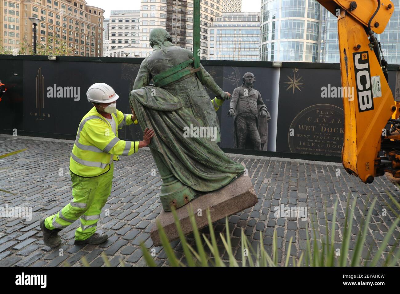 Arbeiter nehmen eine Statue des Sklavenbesitzers Robert Milligan am West India Quay, East London, ab, während Arbeiterräte in England und Wales beginnen, Denkmäler und Statuen in ihren Städten zu überprüfen, nachdem ein Protest antirassistische Aktivisten eine Statue eines Sklavenhändlers in Bristol niederreißen sah. Stockfoto