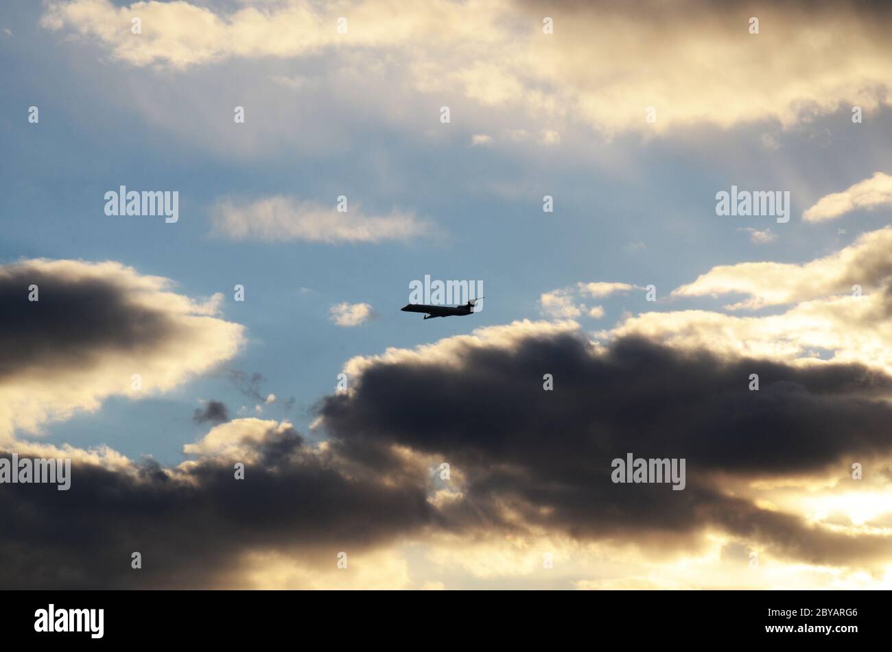 FLUG 419: Kommerzielle Flugzeuge starten von einem nahe gelegenen Newark International Airport in New Jersey in die untergehende Wolkenlandschaft an einem Frühlingstag. Stockfoto