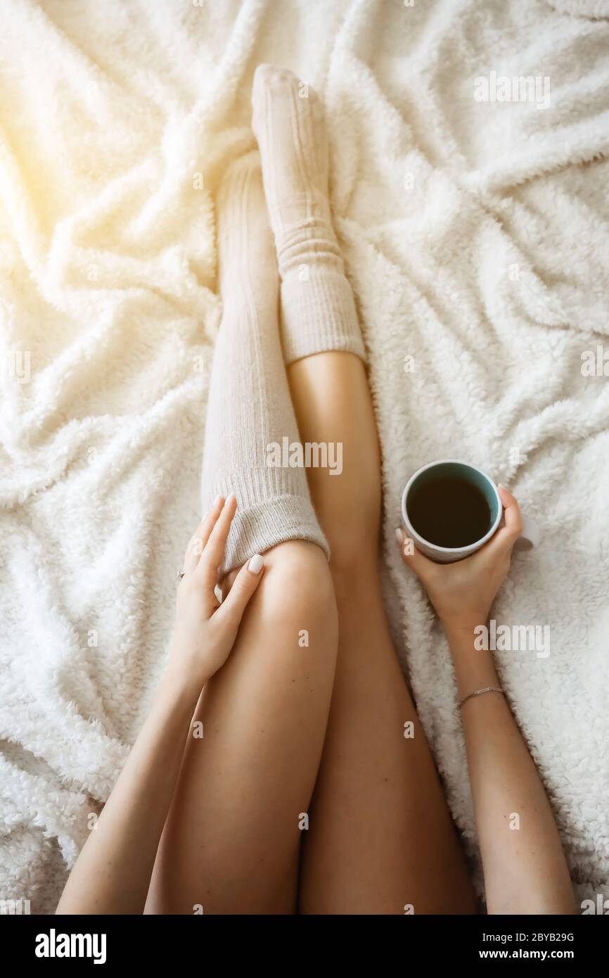 Frau im Bett trinkt Kaffee. Glückliches Mädchen. Morgenkonzept. Frühstück im Bett Stockfoto