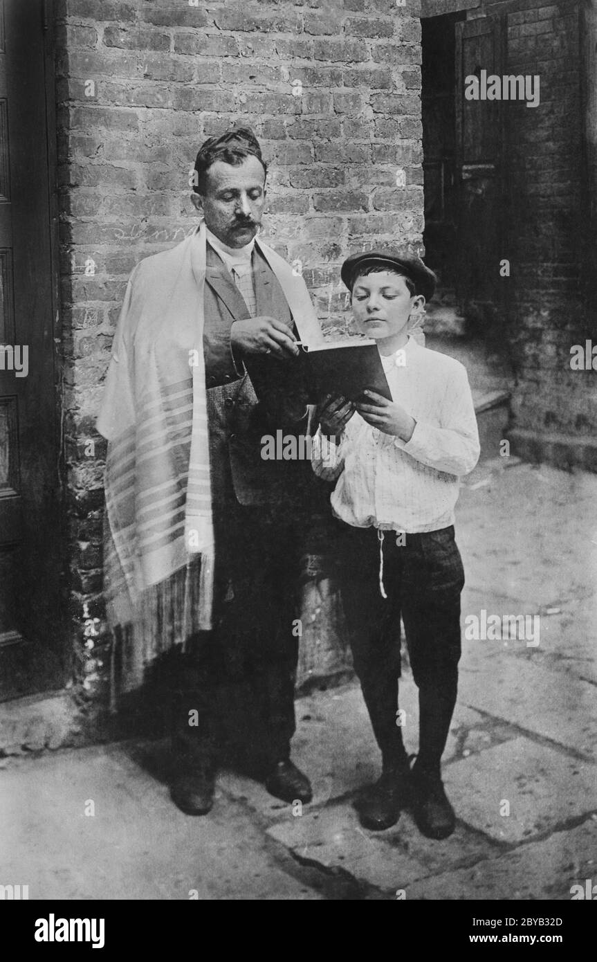 Rabbi und Junge lesen Buch, während sie draußen stehen, in der Nähe des Eingangs zum Gebäude am jüdischen Neujahr, New York City, New York, USA, Bain Nachrichtendienst, September 1907 Stockfoto
