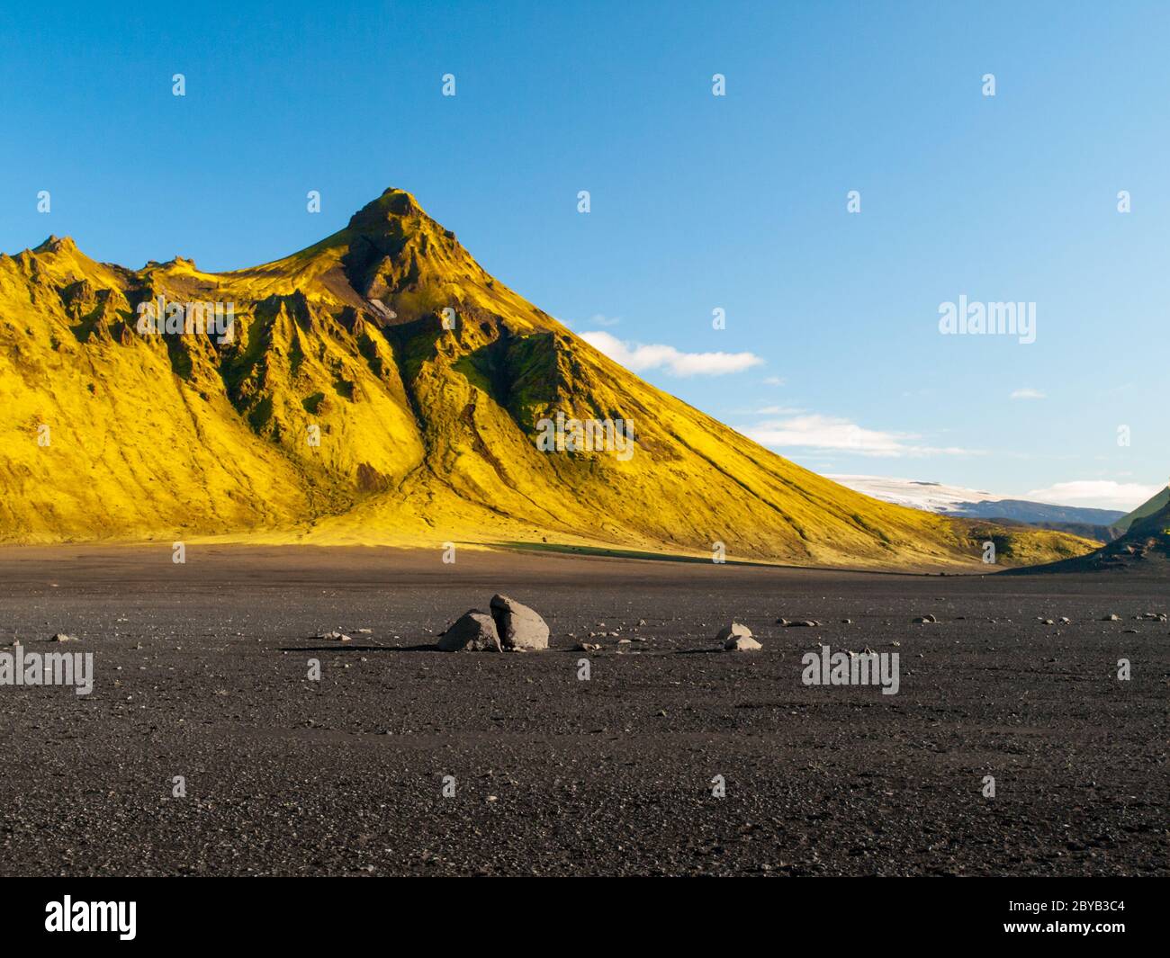 Grüne Hügel und schwarze felsige Böden der isländischen Highlands entlang des Laugavegur Wanderweges, Island. Sonnige Sommertag Aufnahme. Stockfoto