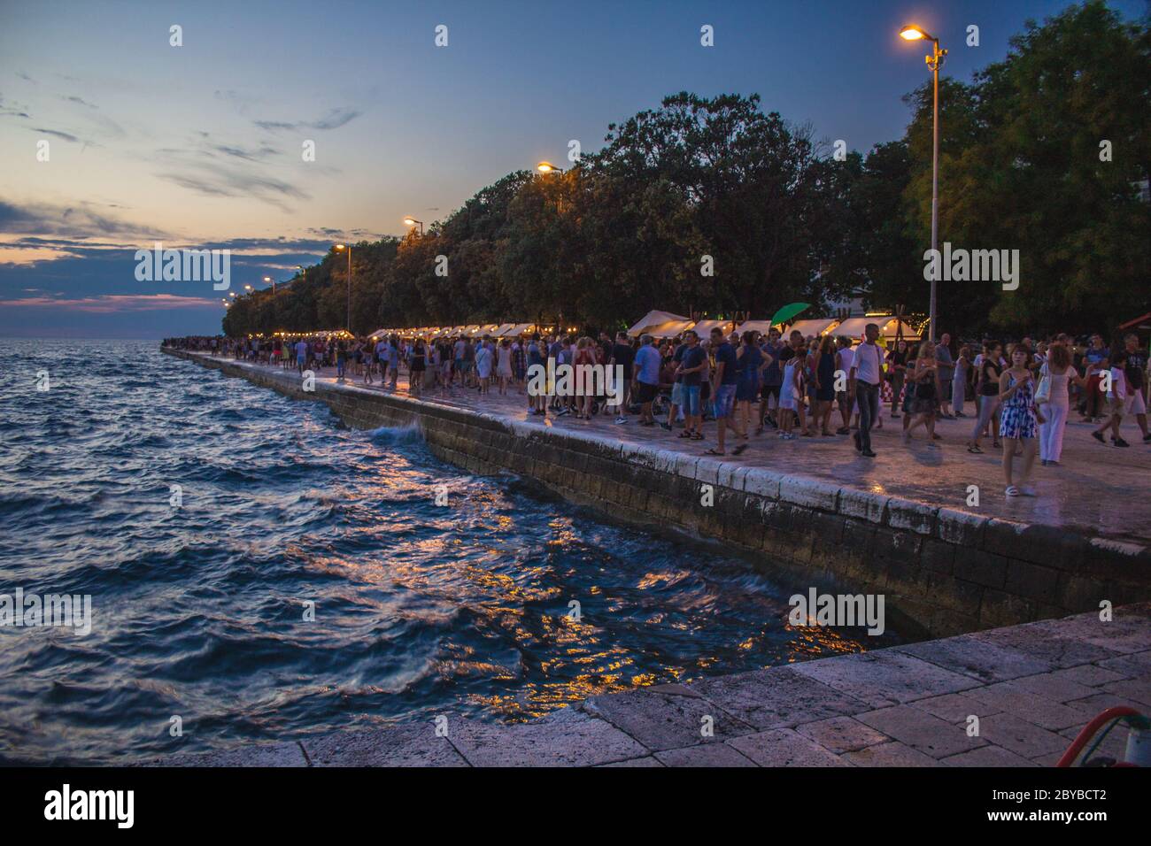 Zadar, Kroatien - Juli 26 2018: Strandpromenade von Zadar bei Nacht. Touristen schlendern durch den Nachtmarkt Stockfoto