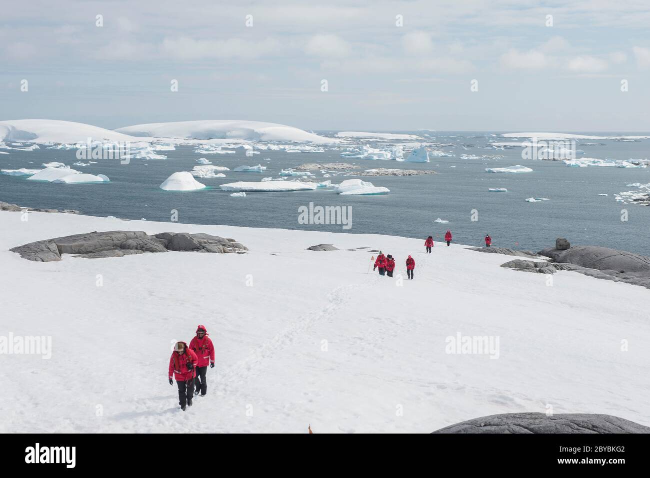 Touristen, die zu Fuß bis zum Cairn in Port Charcot Antarctica. Stockfoto