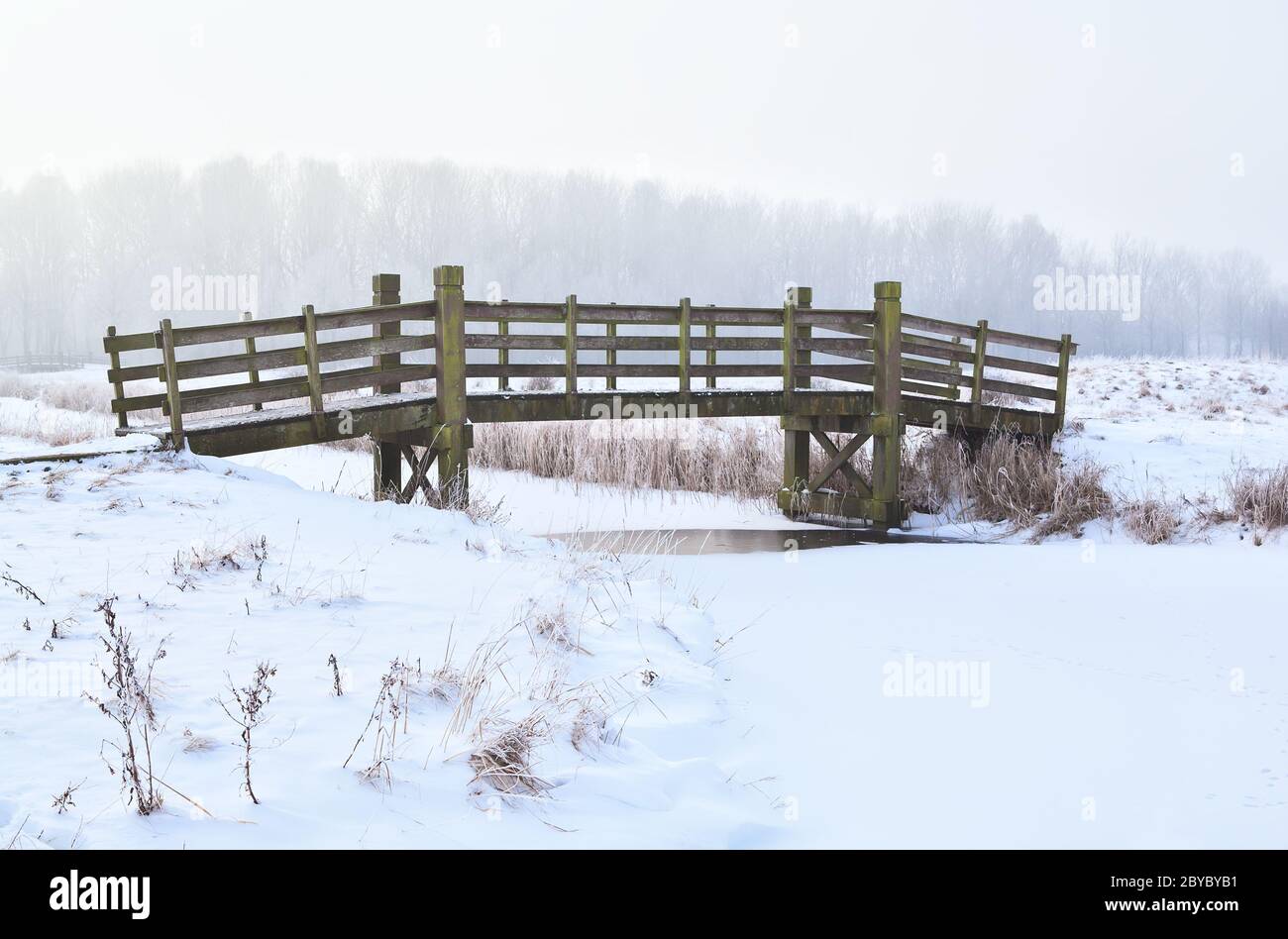 Holzbrücke über gefrorenen Fluss Stockfoto