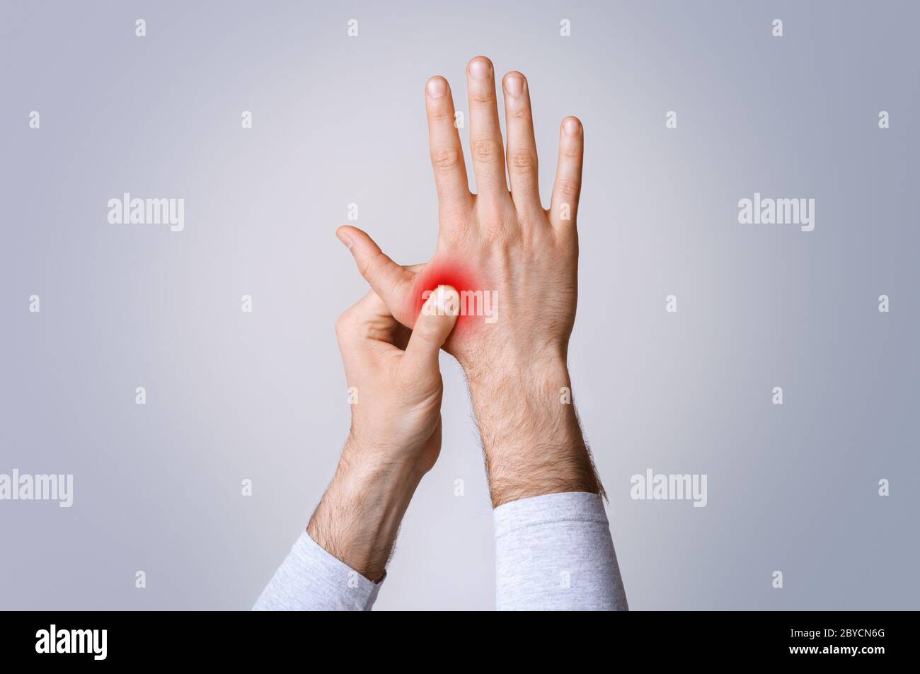 Entzündung in Muskeln und Gelenken. Mann hält an hervorgehobener roter Hand Stockfoto