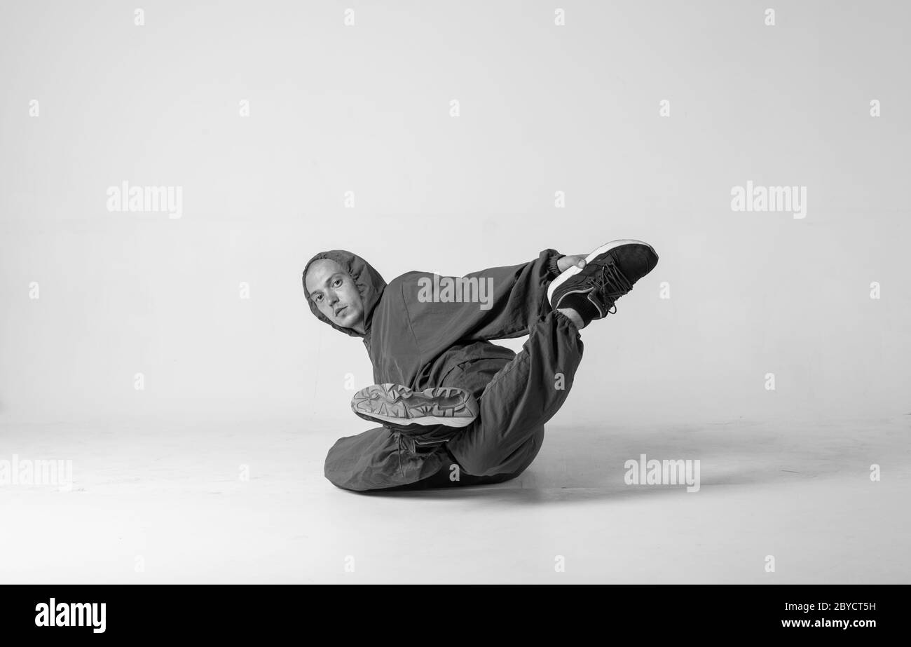 Ein Mann Hip Hop Tänzer oder bboy friert in einer Pose auf weißem Hintergrund. Bboy macht stylische Stunts. Stockfoto