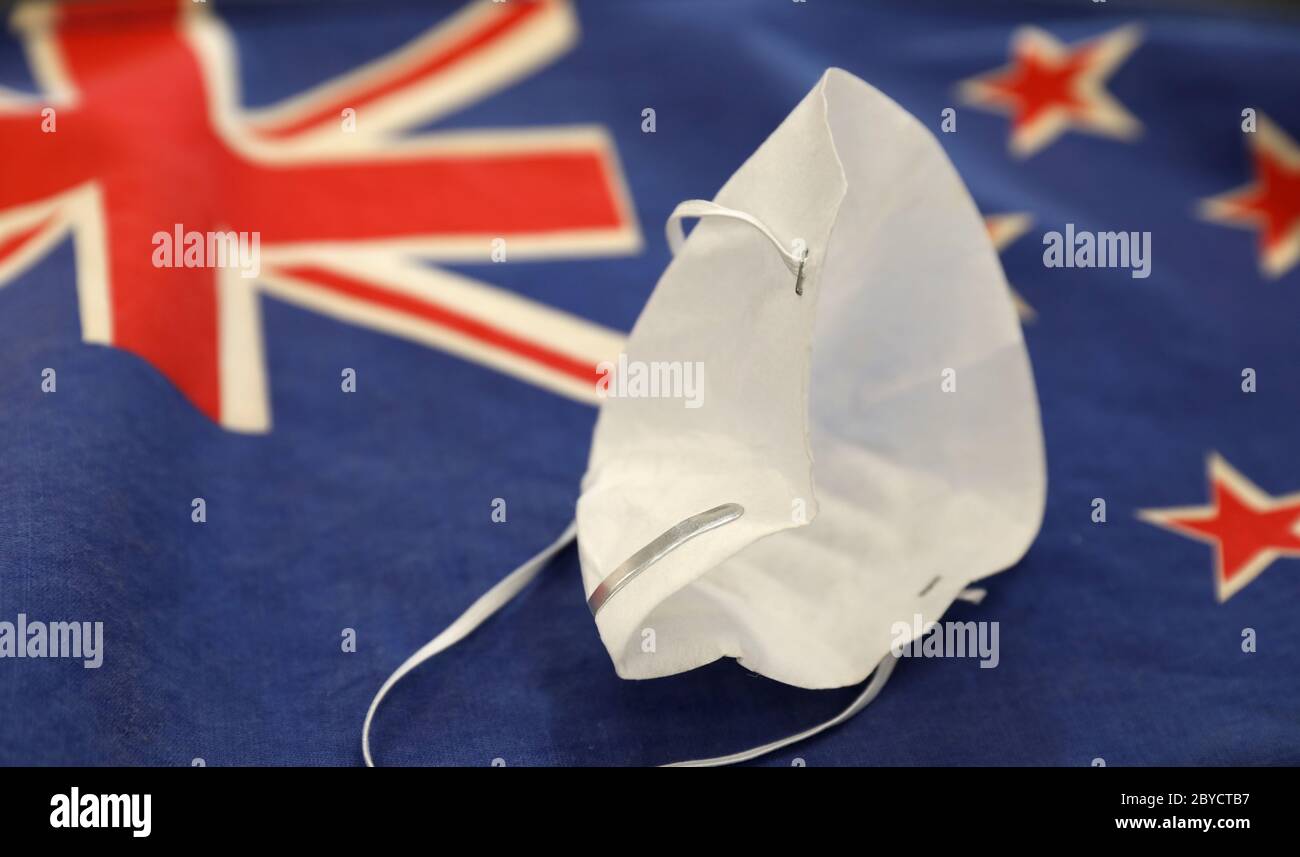 Zerknitterte Gesichtsmaske nach Neuseeland erfolgreich schlägt das Covid-19 Corona Virus ermöglicht das öffentliche Leben wieder normal. Flagge Neuseelands. Erfolgreich Stockfoto