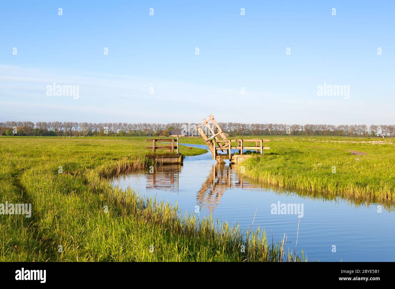 Kleine hölzerne offene Brücke über den niederländischen Kanal Stockfoto