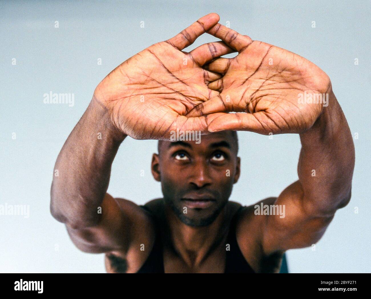 Ein Mann, der Yoga in einem weißen Raum macht. Stockfoto