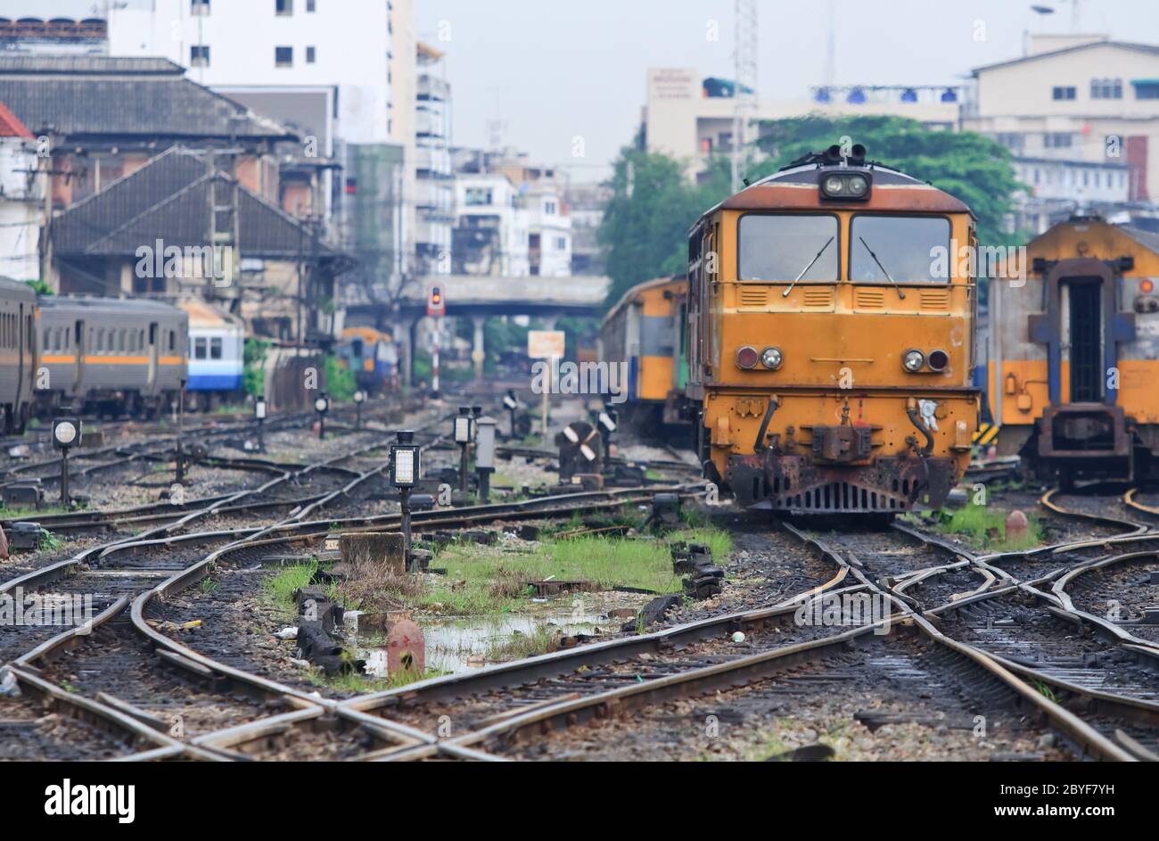 Orange-Zug-Lokomotive Annäherung an Bahnhof Bangkok Thailand mit Eisenbahnknotenpunkt. Stockfoto