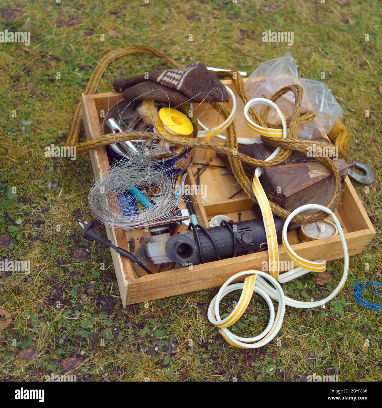 Box mit Sammlung von alten Haushaltswaren auf dem Boden verlassen Stockfoto