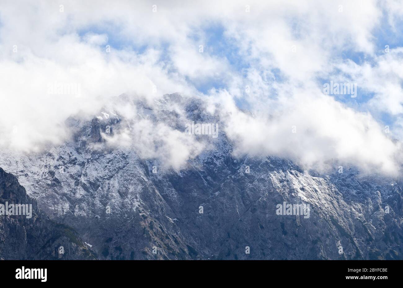 Hoher Berggipfel in weißen Wolken Stockfoto