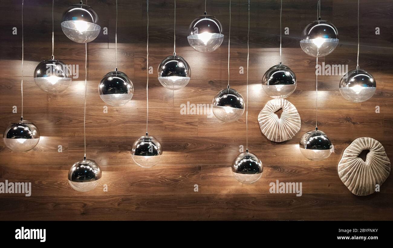 Viele runde Lampen in der Nähe einer braunen Holzwand. Runde Lichter im  Innenraum. Hintergrund für Design. Dekorative Glühlampen Stockfotografie -  Alamy