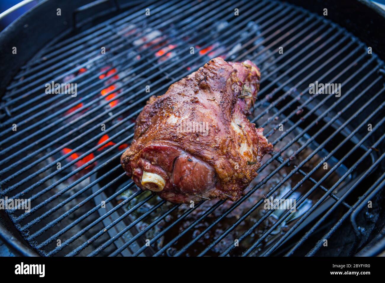 Eine marinierte Schulter des Lammes Kochen auf einem Außenkohlegrill Stockfoto