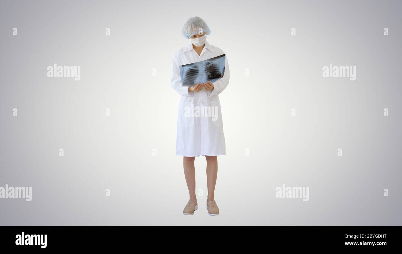 Frau Arzt in Maske Blick auf Lunge Röntgenstrahlen auf Gradienten Hintergrund. Stockfoto