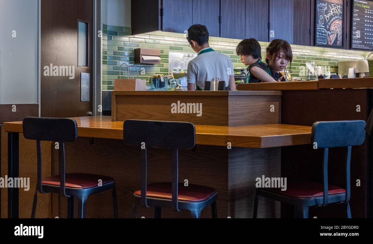 Barista hinter dem Tresen in einem Starbucks Coffee House Outlet, Tokio, Japan Stockfoto