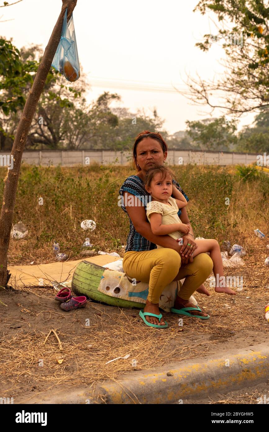 Damariz (27) und Anita (3) sitzen am Straßenrand und bitten um Hilfe.die Coronavirus-Krise und die Blockierung in Honduras waren besonders hart für die Schwächsten: 50% der Menschen leben in Armut. Ohne Arbeit und wenig bis gar keine Hilfe der Regierung sind Tausende von Menschen auf die Straße gegangen und hoffen auf einen guten Willen von Passanten. Stockfoto