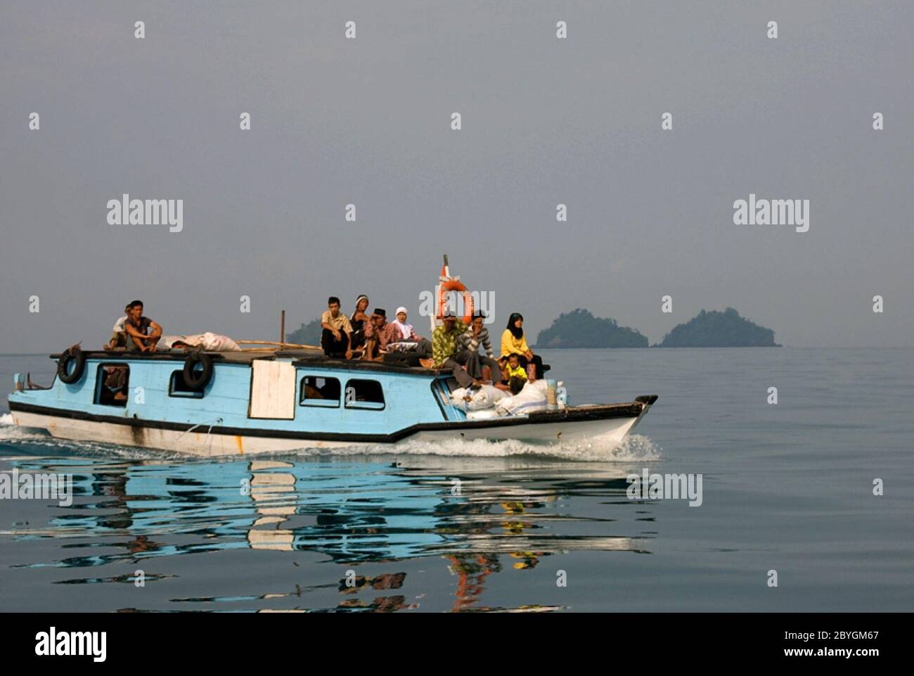 Ein vollgepacktes Passagierboot aus Holz, das auf dem Meer fährt und kleine Inseln der Sundastraße mit der Provinz Lampung auf dem Festland Sumatra verbindet. Sunda Strait, Indonesien. Stockfoto