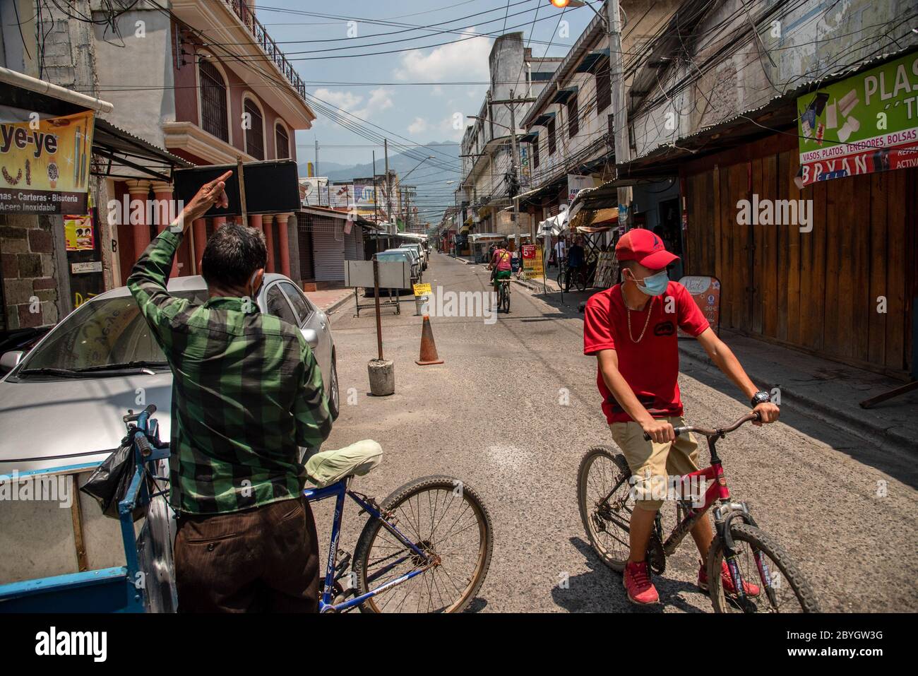 23. Mai 2020, San Pedro Sula, Honduras: Ein Mann, der vorbeugend eine Gesichtsmaske trägt, fährt mit dem Fahrrad durch einen verlassenen Marktplatz. Honduras hat eine "intelligente Wiedereröffnung" eingeführt, die es allen kommerziellen Unternehmen erlaubt, sich zu öffnen, aber alle Mitarbeiter und Kunden dazu auffordert, Masken zu tragen. (Bild: © Seth Sidney Berry/SOPA Images via ZUMA Wire) Stockfoto