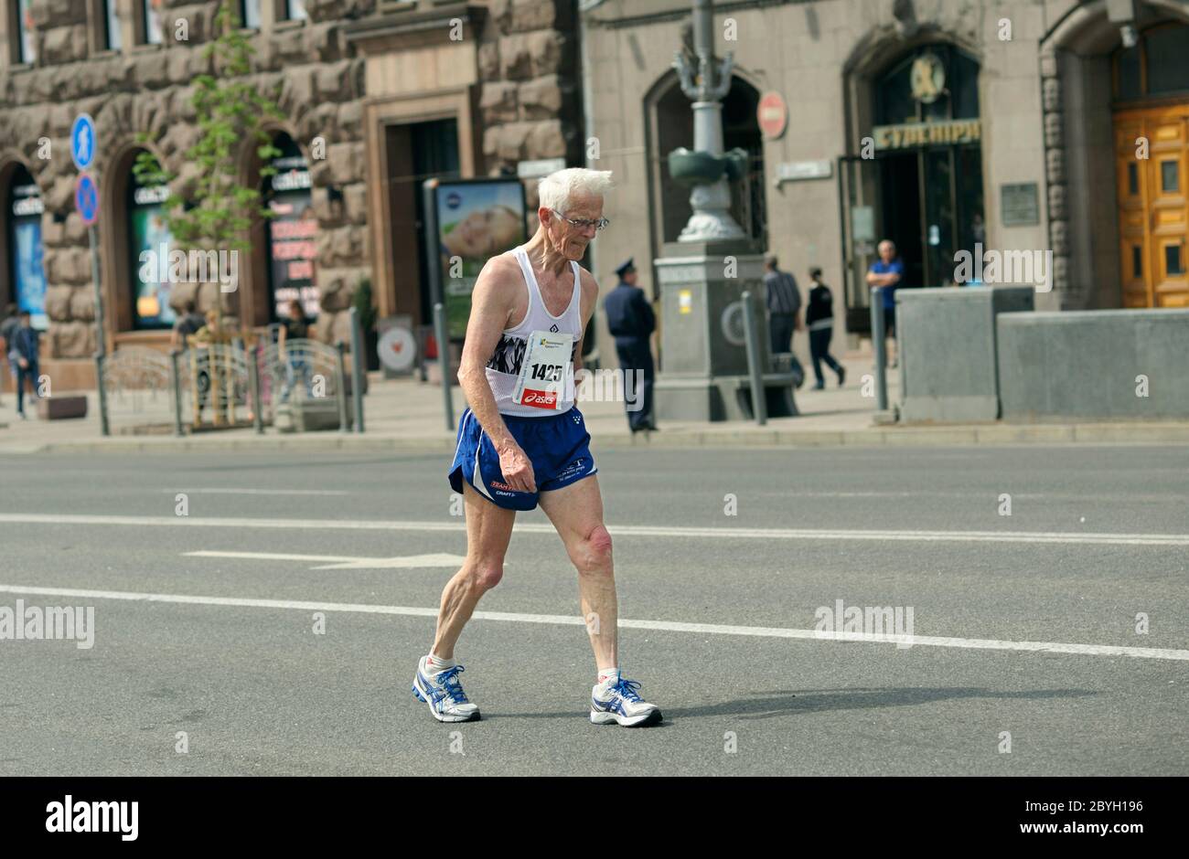 Ein alter Mann im Trainingsanzug läuft die Straße hinunter. Marathon unter  Amateuren gewidmet dem Tag der Stadt Stockfotografie - Alamy