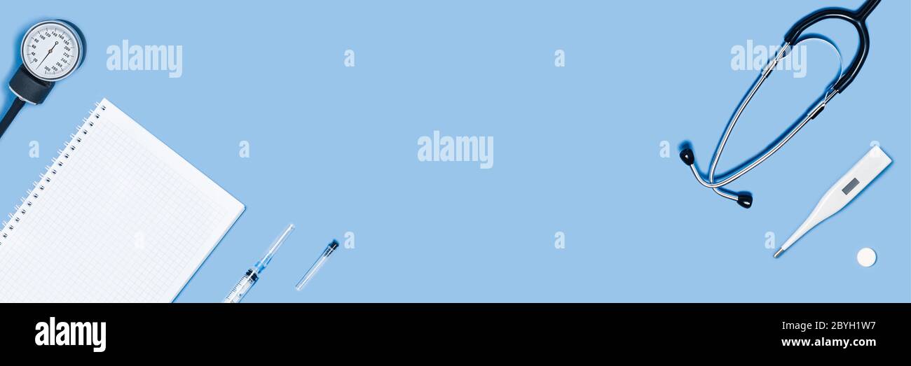 Medizinisches Zubehör auf blauem Webbanner: Stethoskop, Thermometer, Tablets, Notizblock. Stockfoto