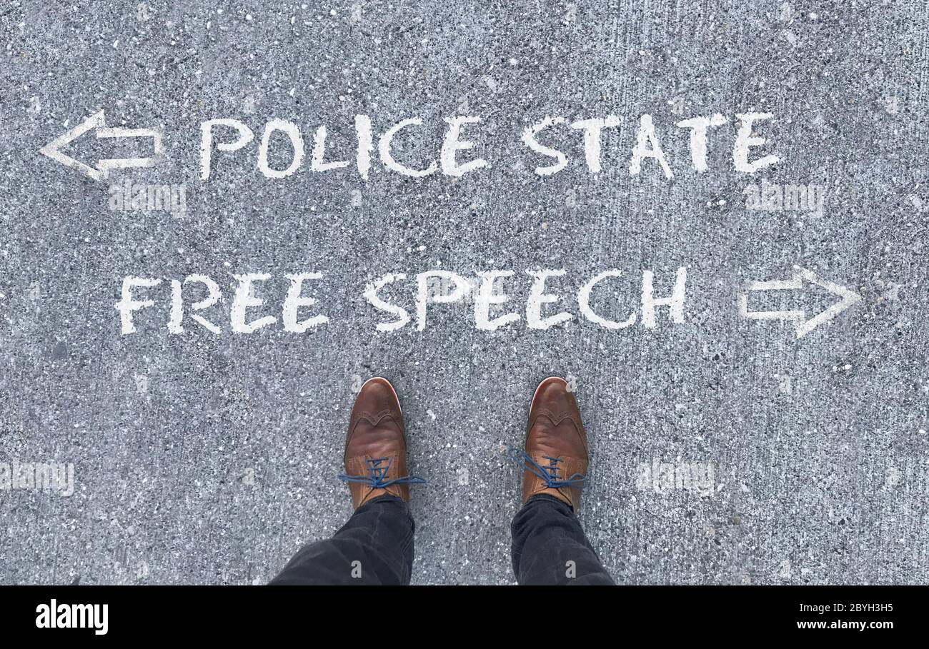 Draufsicht auf einen Mann, der vor den Worten "Polizeistaat" und "freie Rede" steht, mit Pfeilen, die nach links und rechts zeigen Stockfoto
